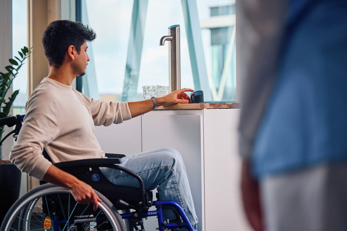 Person in a wheelchair interacting with the Easy Access Panel in an office setting 